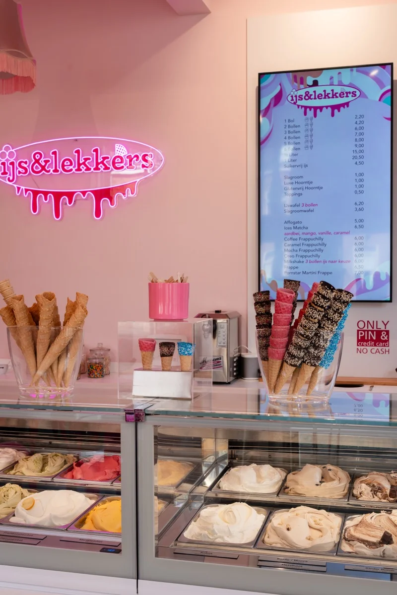 Breed overzicht van het interieur van IJs & Lekkers Delft met toonbank, neonbord en ijsvitrine